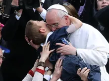 Pope Francis embraces a boy prior to his first 'Urbi et Orbi' blessing on Easter Sunday, March 31, 2013. 