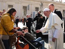 Pope Francis gives a rosary to a disabled child during his general audience Feb. 24, 2016. 