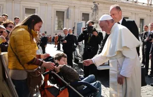 Pope Francis gives a rosary to a disabled child during his general audience Feb. 24, 2016.  