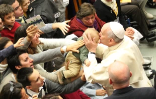 Pope Francis kisses a baby at a Pontifical Council for Health Care conference on autism Nov. 22, 2014.   Petrik Bohumil / CNA.