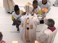 Pope Francis blesses the child's family after they presented the gifts at Mass, July 28, 2013. 