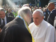 Pope Francis greets a local priest during his visit to the 