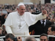 Pope Francis greets pilgrims as he rides through St. Peters Square during his General Audience on Nov. 25, 2013 