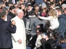Pope Francis greets a family of pilgrims in St. Peter's Square, Dec. 4, 2013. 