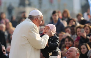 Pope Francis kisses a child 1 in St. Peter's Square for the general audience, Dec. 9, 2015.   Daniel Ibanez/CNA.