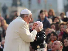 Pope Francis kisses a child in St. Peter's Square for the general audience, Dec. 9, 2015. 