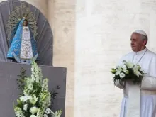 Pope Francis lays flowers at the foot of the statue of Our Lady of Lujan on May 8, 2013. 