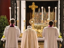 Pope Francis, together with his masters of ceremonies, reverences the Eucharist at St. Mary Major's in Rome following the Corpus Christi procession, June 19, 2014. 