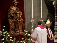 Pope Francis prays before a statue of Mary in St. Peter's Basilica. 