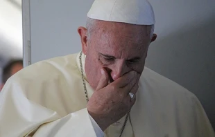 Pope Francis prays with journalists on the papal flight en route to South Korea on Aug. 14, 2014.   Alan Holdren/CNA.