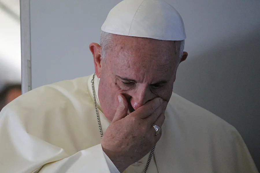 Pope Francis prays with journalists on the papal flight en route to South Korea. Aug. 14, 2014. ?w=200&h=150