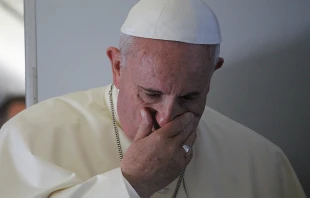 Pope Francis prays with journalists on the papal flight en route to South Korea. Aug. 14, 2014.  Alan Holdren/CNA.