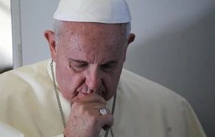Pope Francis prays with journalists on the papal flight en route to South Korea on Aug. 14, 2014.   Alan Holdren/CNA.