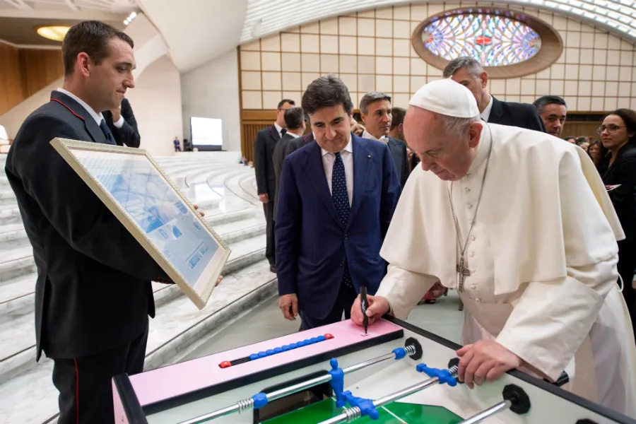 Pope Francis signs a foosball table during his meeting with participants in a meeting promoted by La Gazzetta dello Sport at the Vatican's Paul VI Hall, May 24, 2019. ?w=200&h=150