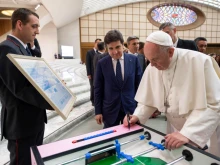 Pope Francis signs a foosball table during his meeting with participants in a meeting promoted by La Gazzetta dello Sport at the Vatican's Paul VI Hall, May 24, 2019. 