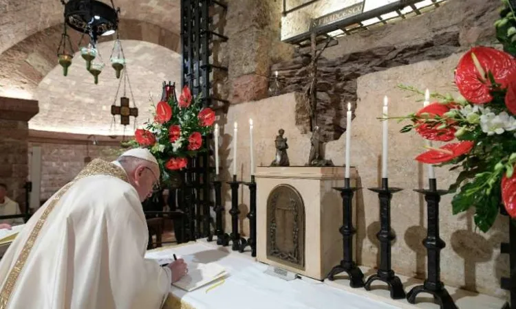 Pope Francis signs his new encyclical Fratelli tutti on the altar before the tomb of St Francis of Assisi on Oct 3 2020 Photo credits  Vatican Media