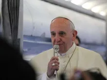 Pope Francis speaks to journalists on a 2014 papal flight. 