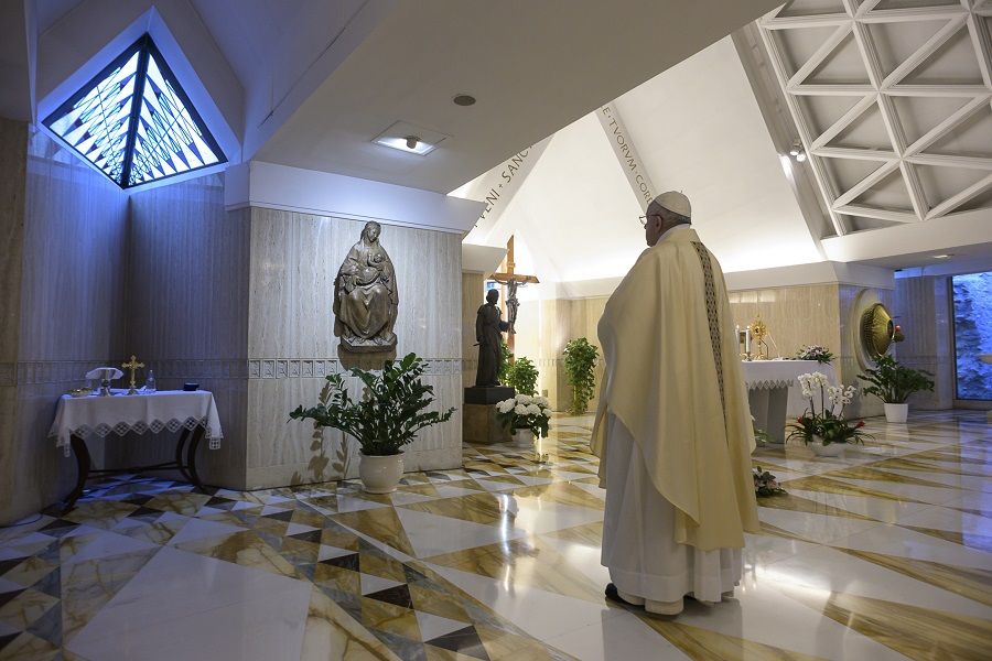 Pope Francis stops before a statue of Mary in the chapel of Casa Santa Marta May 4, 2020. ?w=200&h=150