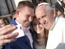 Pope Francis takes a selfie with a newly married couple in St. Peter's Square, Dec. 2, 2015. 
