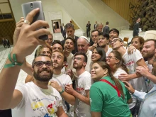 Pope Francis takes a selfie with members of the International Eucharistic Youth Movement in the Vatican's Paul VI Hall, Aug. 7, 2015. 