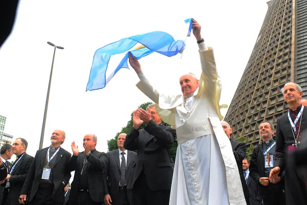 Pope Francis waves an Argentine flag during World Youth Day 2013. Alex Mazzullo/JMJ Rio 2013 via Flickr (CC BY-NC-SA 2.0).