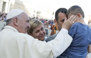 Pope Francis with a family on June 14, 2015 in St. Peter's Square.   L'Osservatore Romano.