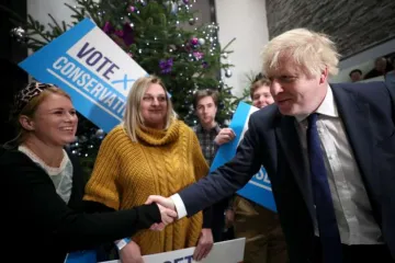 Prime Minister Boris Johnson greets a woman as he arrives to attend a campaign rally event Dec 2 2019 in Colchester England Credit Hannah McKay   WPA Pool Getty Images