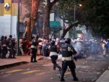  Protesters run from riot police on Feb. 15, 2014 in Altamira, Caracas, Venezuela. 