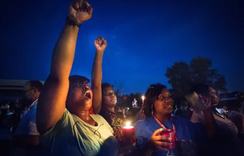 Protestors held candles as they shouted hands up during a protest in Ferguson. ?w=200&h=150