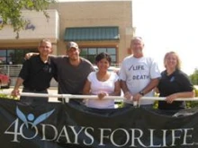 Ramona Trevino, center, with the former Sherman, TX Planned Parenthood in the background.