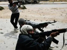 Rebels fire at government troops during street fighting in Libya. 