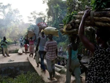 Refugees from Ivory Coast make their way across a plank bridge on their way to Liberia. 