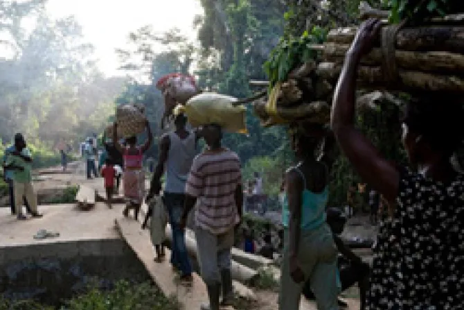 Refugees from Cte d Ivoire make their way across a plank bridge on the road to Janzon in Liberia Photo Credit UNHCR G Gordon CNA World Catholic News 3 30 11