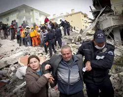 Relatives of an earthquake victim are led away from ruins by a policeman, on October 25, 2011 in Van, Turkey. ?w=200&h=150
