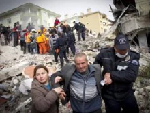 Relatives of an earthquake victim are led away from ruins by a policeman, on October 25, 2011 in Van, Turkey. 