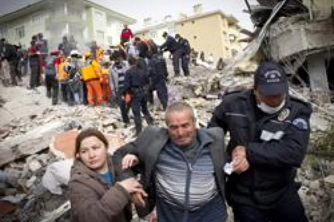 Relatives of an earthquake victim are led away from ruins by a Policeman on October 25 2011 in Van Turkey Credit Ahmad Halabisaz Getty Images News Getty Images CNA World Catholic News 10 26 11