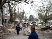 Residents walk down a street along Chef Menture Ave after a tornado touched down in the eastern part of the city on Feb. 7, 2017 in New Orleans. 