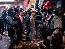 Riot police detain two men after clearing protesters from the Central district in Hong Kong, Nov. 13, 2019. 