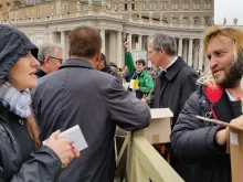 Rome's homeless join volunteers in handing out copies of the Gospel to pilgrims in St. Peter's Square, March 22, 2015. 