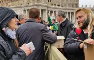 Rome's homeless join volunteers in handing out copies of the Gospel to pilgrims in St. Peter's Square, March 22, 2015.   Martha Calderon/CNA.