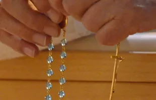 A Catholic prays the Rosary.   Mazur-catholicchurch.org.uk.