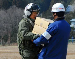 U.S. Navy Lt. Cmdr. Albin Quinko delivers supplies to a Japanese aid worker. ?w=200&h=150