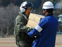 U.S. Navy Lt. Cmdr. Albin Quinko delivers supplies to a Japanese aid worker. 