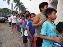Children queue outside a shelter in Guatemala in 2018. 