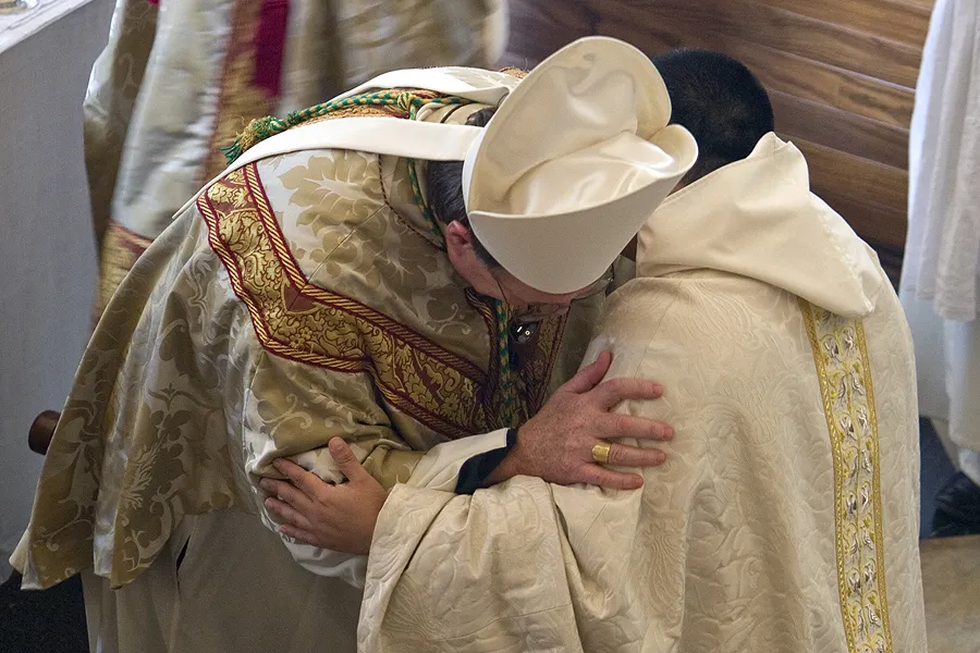 A bishop and a priest exchange the sign of peace during Mass.?w=200&h=150