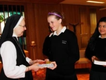 Sister Jane de Chantal Smisek presents a Bible to Visitation freshman Colleen Scallen. 