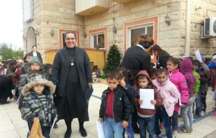 Sister Sanaa Hana, who was forced from her convent in Mosul by the Islamic State, is seen in Erbil with children in front of a house where she has found refuge.   Aid to the Church in Need. 