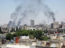 Smoke billows skyward as buildings are shelled in Homs, June 9, 2012. 