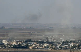 Smoke rises from the Syrian town of Ras al-Ayn during the Turkish offensive against Kurdish groups in northeastern Syria, Oct. 17, 2019, as seen from Turkey.   Ozan Kose/AFP via Getty Images.