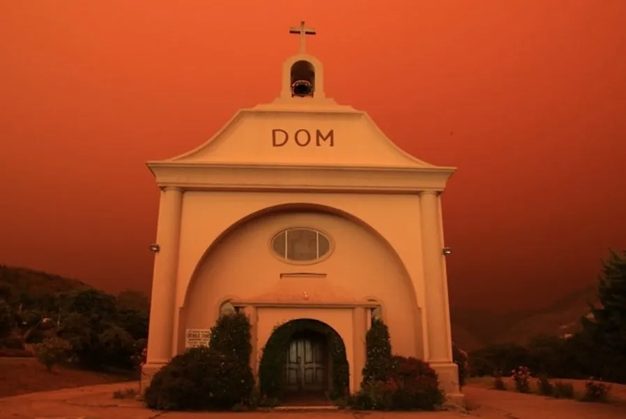 St. Vincent de Paul parish in Davenport, California, surrounded by an orange glow from an approaching fire. Photo provided by the Diocese of Monterey. ?w=200&h=150